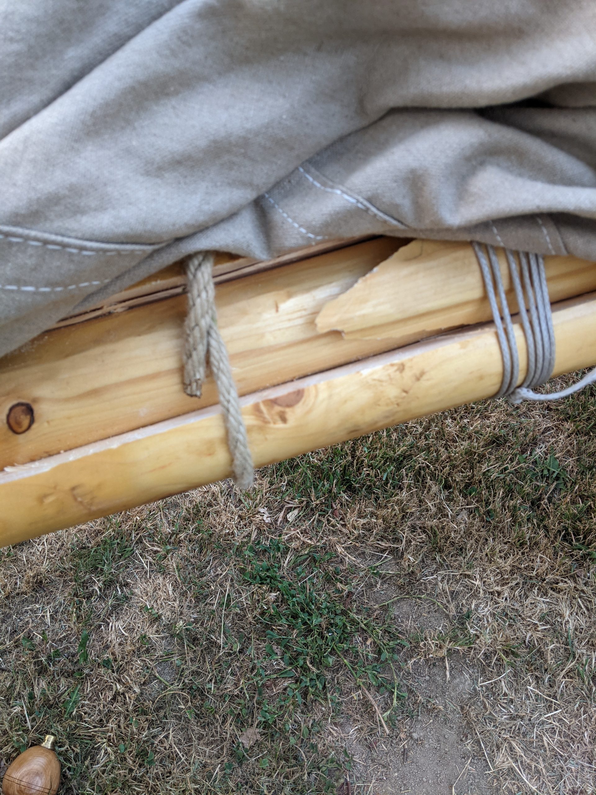 Ein Segel und eine mit Schnüren und Holz geschiente Rute.