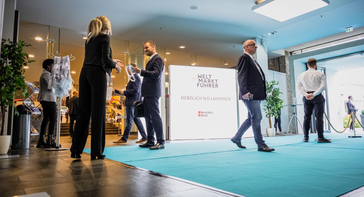 Mehrere Menschen befinden sich in einer großen Halle.