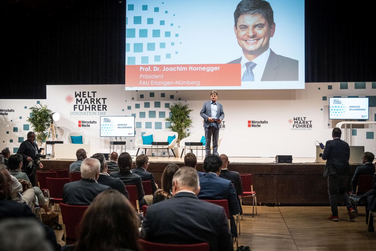 Ein Mann steht auf einer Bühne und hält eine Rede.