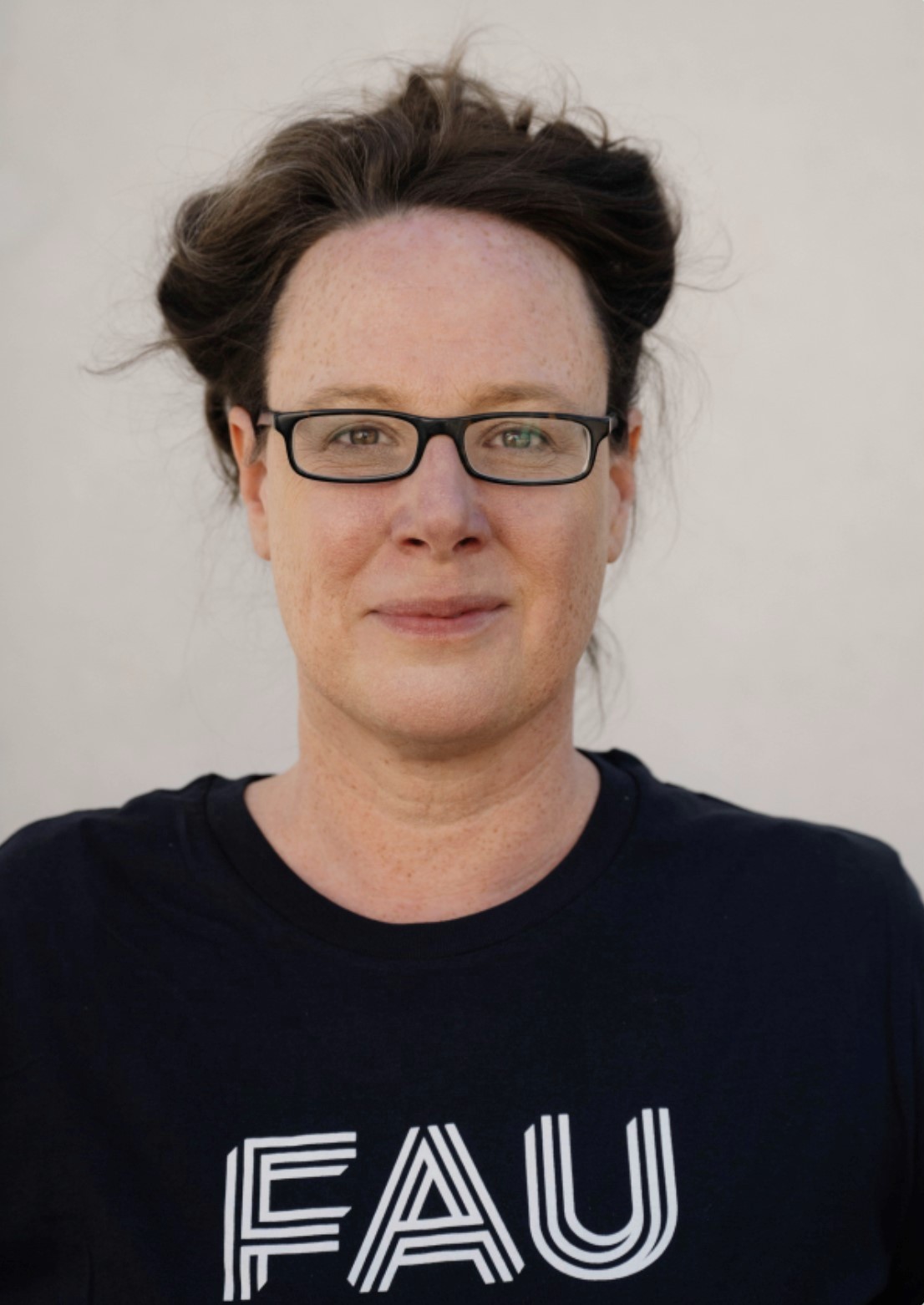 Eine Frau mit Brille und langen braunen Haaren.