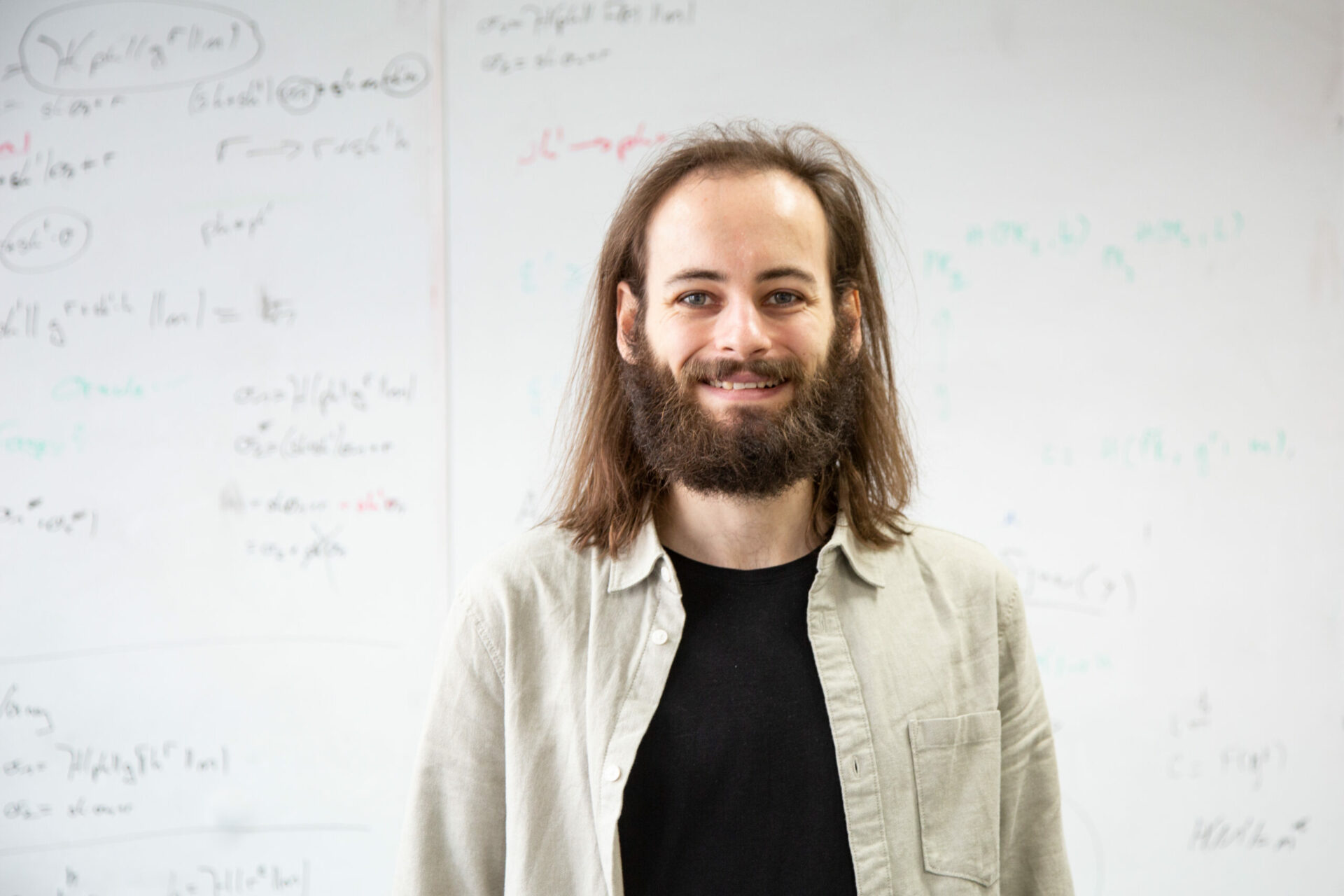 Mann steht vor Whiteboard.