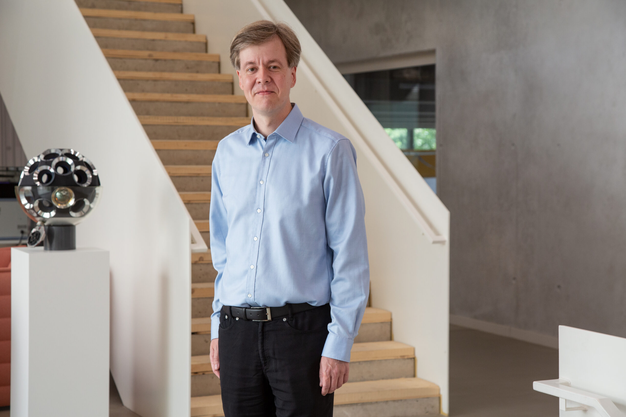 Prof. Dr. Claudio Kopper steht vor Treppenhaus