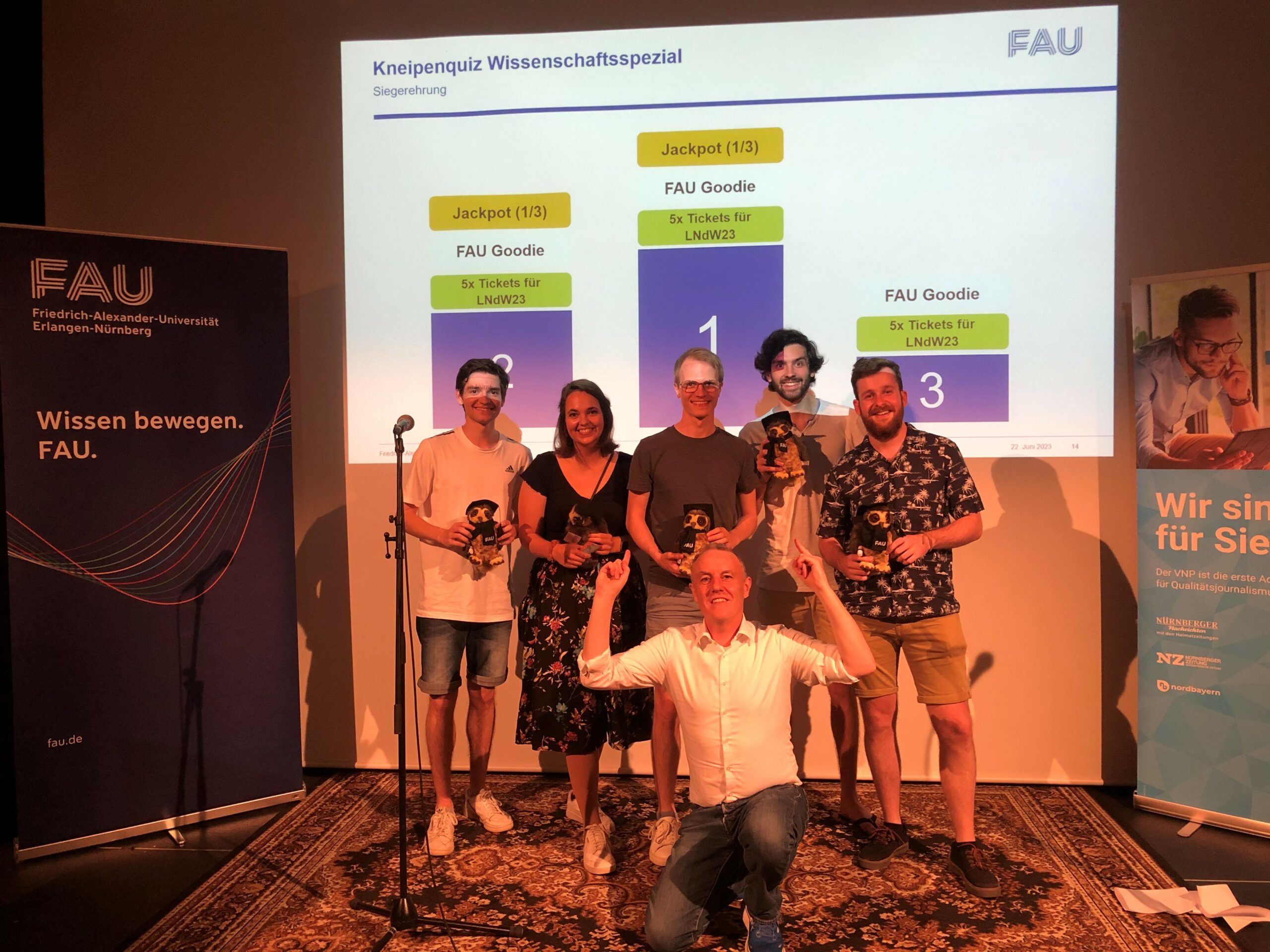 FAU-Kneipenquiz in der Kellerbühne im E-Werk: Bühne mit Moderation, Tische mit Teilnehmenden