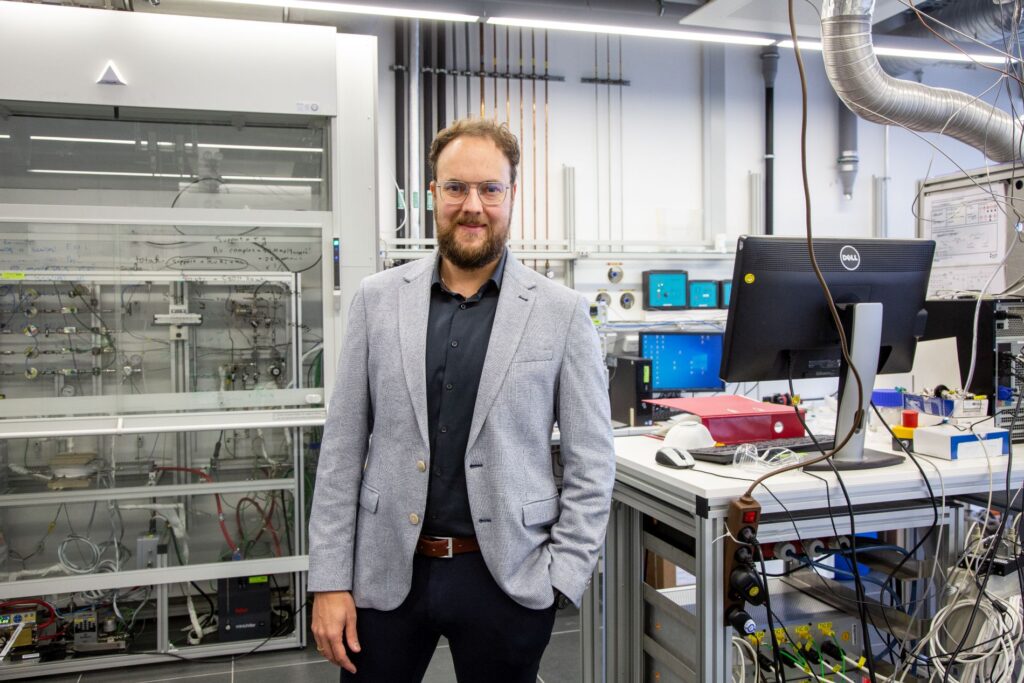 Dr.-Ing. Patrick Schühle von der FAU steht in einem Labor.