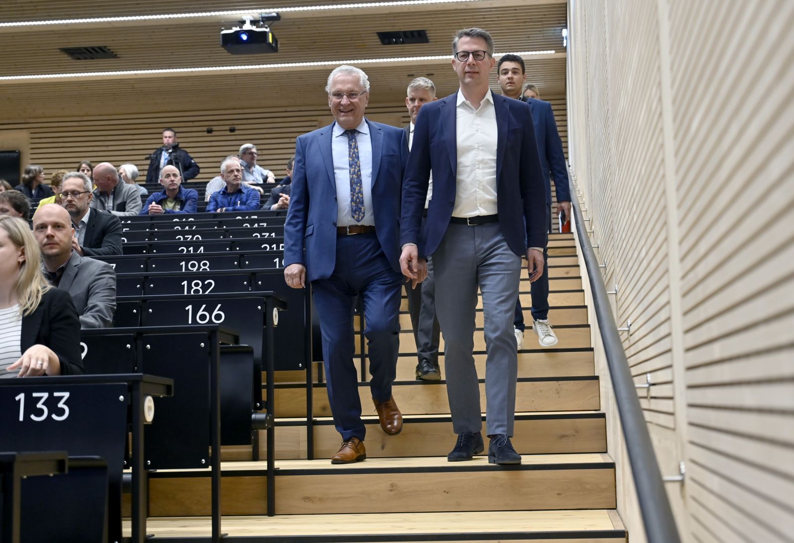 Menschen gehen Treppe hinab in Hörsaal der Gruppenfoto vor neuem Hörsaalgebäude der Friedrich-Alexander-Universität Erlangen-Nürnberg in Erlangen