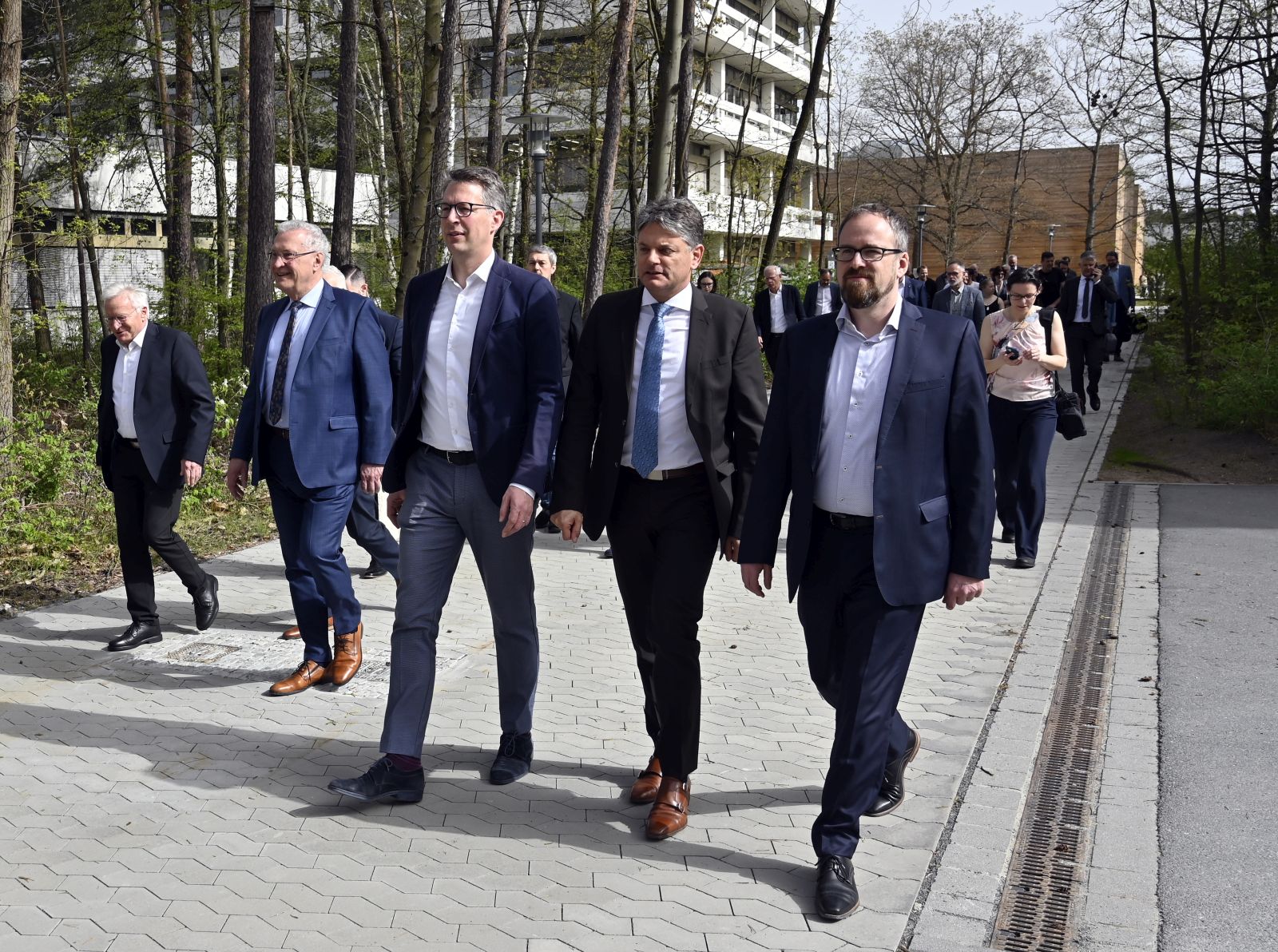 Menschen gehen auf Straße zum Spatenstich auf dem Baufeld des Neubaus der Technischen Chemie der Friedrich-Alexander-Universität Erlangen-Nürnberg in Erlangen