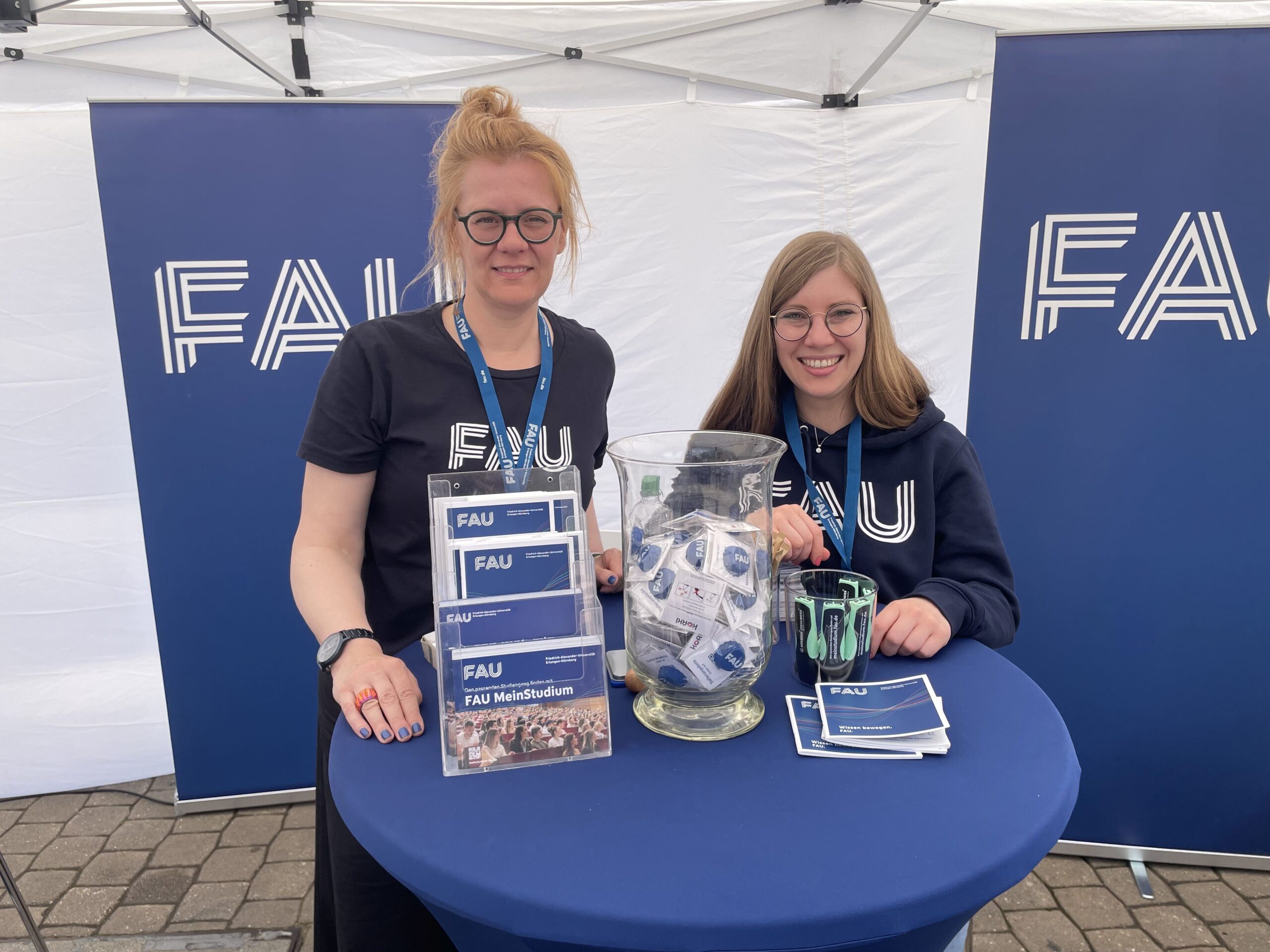 FAU-Angestellte am FAU-Stand beim Erlanger Jobwalk. Bewerben Sie sich jetzt an der Friedrich-Alexander-Universität-Erlangen-Nürnberg! Es gibt viele attraktive Stellen