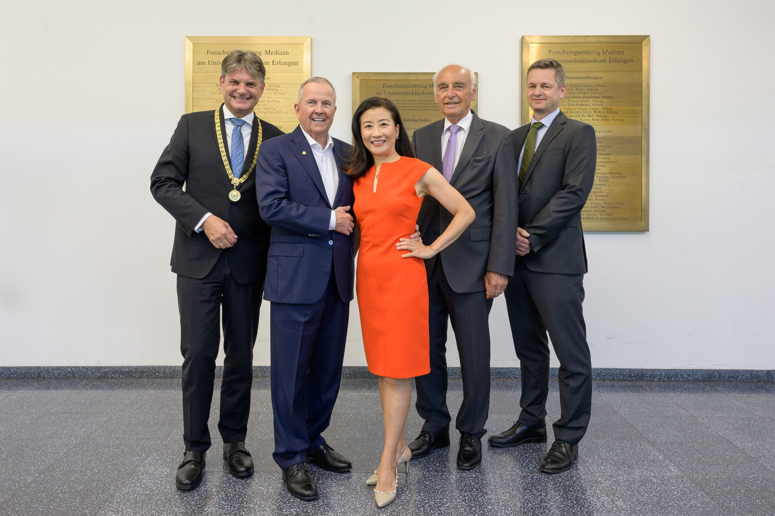 Von links nach rechts: Prof. Dr. Joachim Hornegger (Stiftungsratsmitglied und FAU-Präsident), Hans-Georg Geis (Stifter), Xue Hong Dong-Geis (Stifterin), Prof. Dr. Dr. h. c. Werner Hohenberger (Stiftungsratsvorsitzender/Forschungsstiftung Medizin) und Prof. Dr. Stephan Achenbach (Vorstandsvorsitzender/Forschungsstiftung Medizin) trafen sich vor der Vertragsunterzeichnung vor der goldenen Stiftertafel, auf der nun auch die neue Namensstiftung – die Hans-Georg Geis und Xue Hong Dong-Geis-Stiftung – aufgelistet ist. Foto: Michael Rabenstein/Uniklinikum Erlangen
