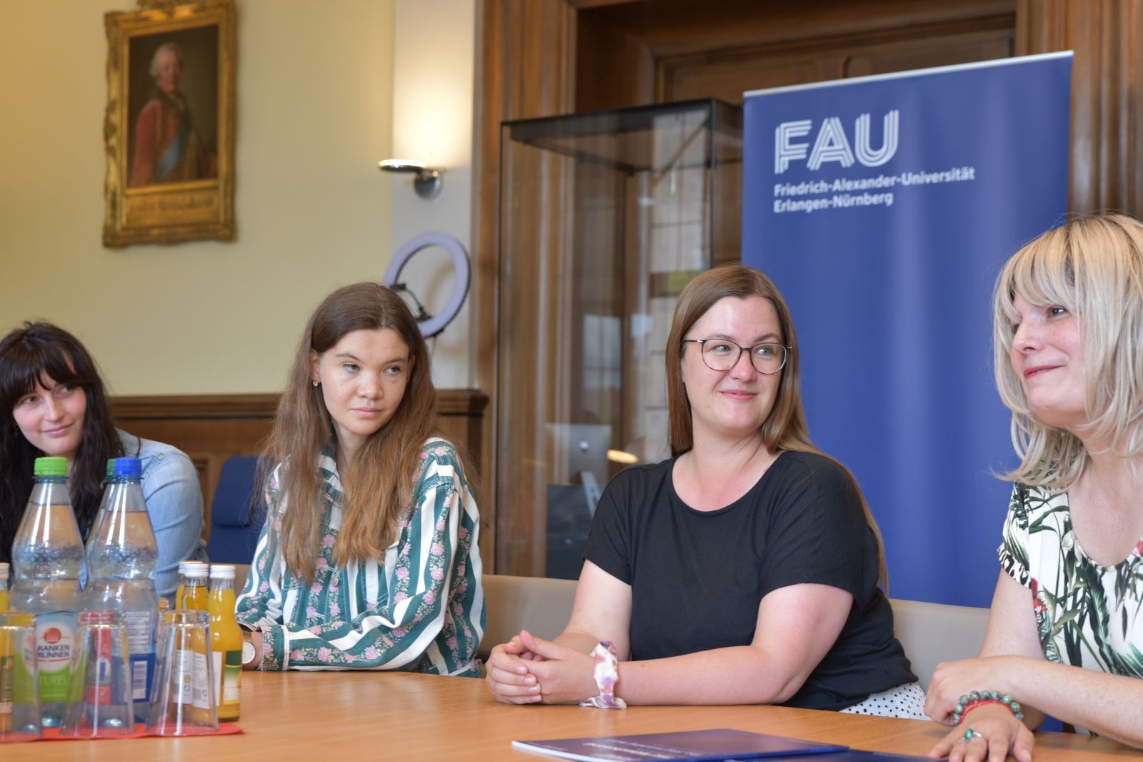 Universitätsleitung sitzt mit Studierenden und Diversitybeauftragten an Tisch und bespricht Wünsche aus der Kampagne Wünschewand.