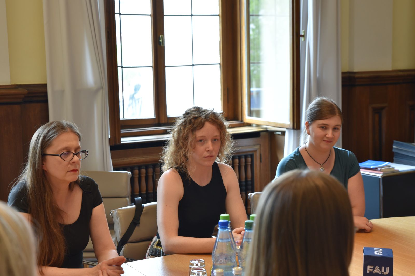 Universitätsleitung sitzt mit Studierenden und Diversitybeauftragten an Tisch und bespricht Wünsche aus der Kampagne Wünschewand.