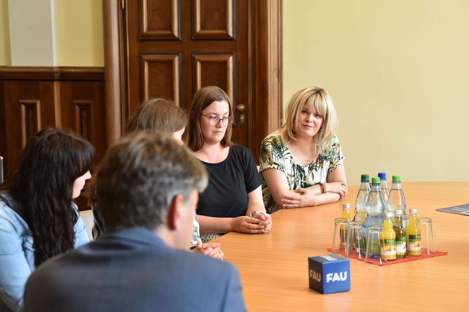 Universitätsleitung sitzt mit Studierenden und Diversitybeauftragten an Tisch und bespricht Wünsche aus der Kampagne Wünschewand.