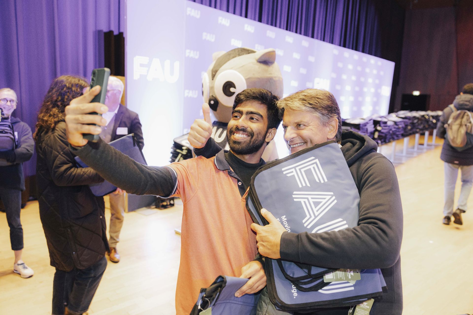 Ein Student macht ein Selfie mit FAU-Präsident Joachim Hornegger bei der Begrüßung.