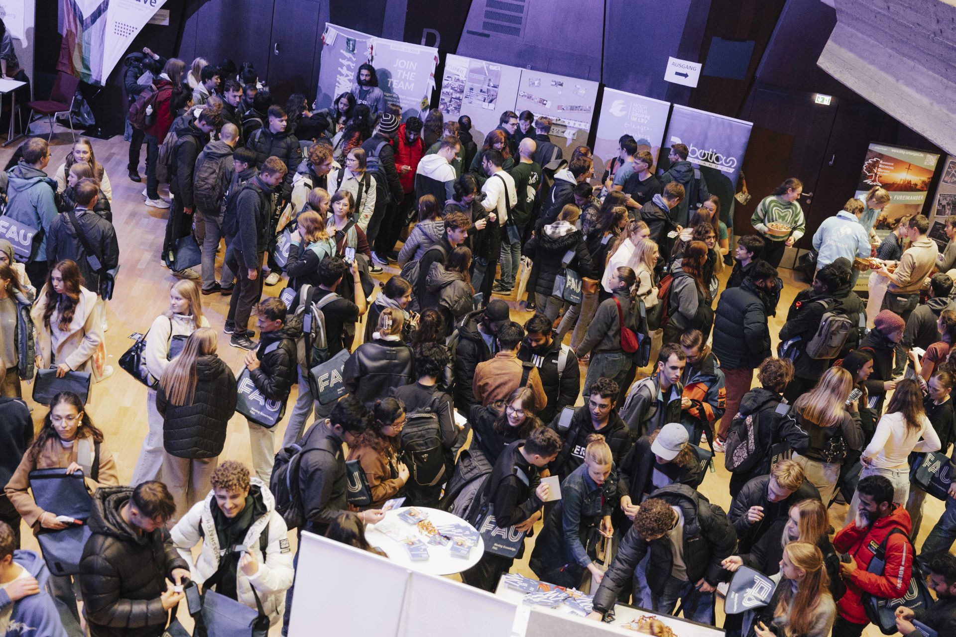 Blick von oben auf die Stände und Menschen in der Halle.