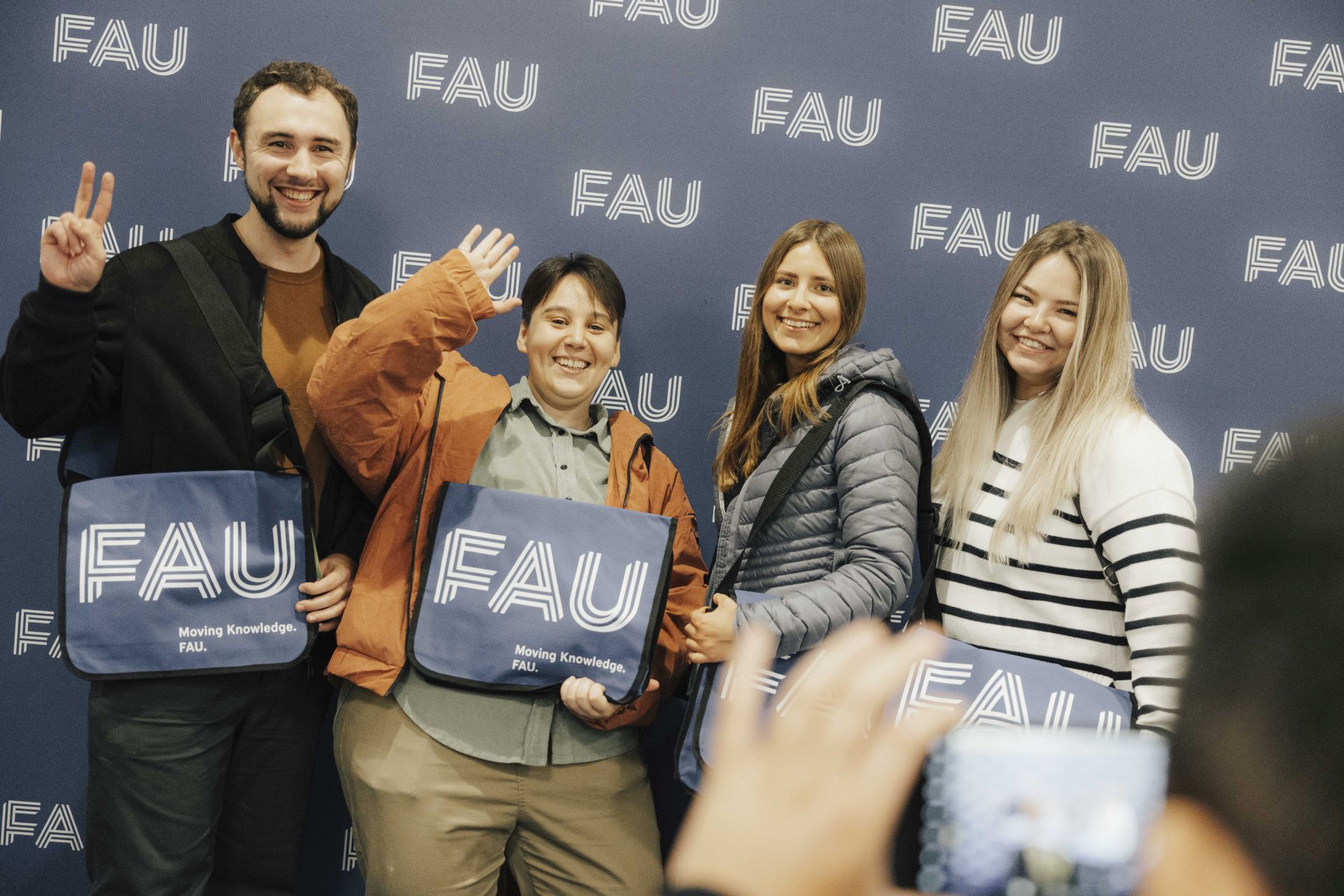 Vier Studierende der FAU. Sie zeigen ihre Taschen.