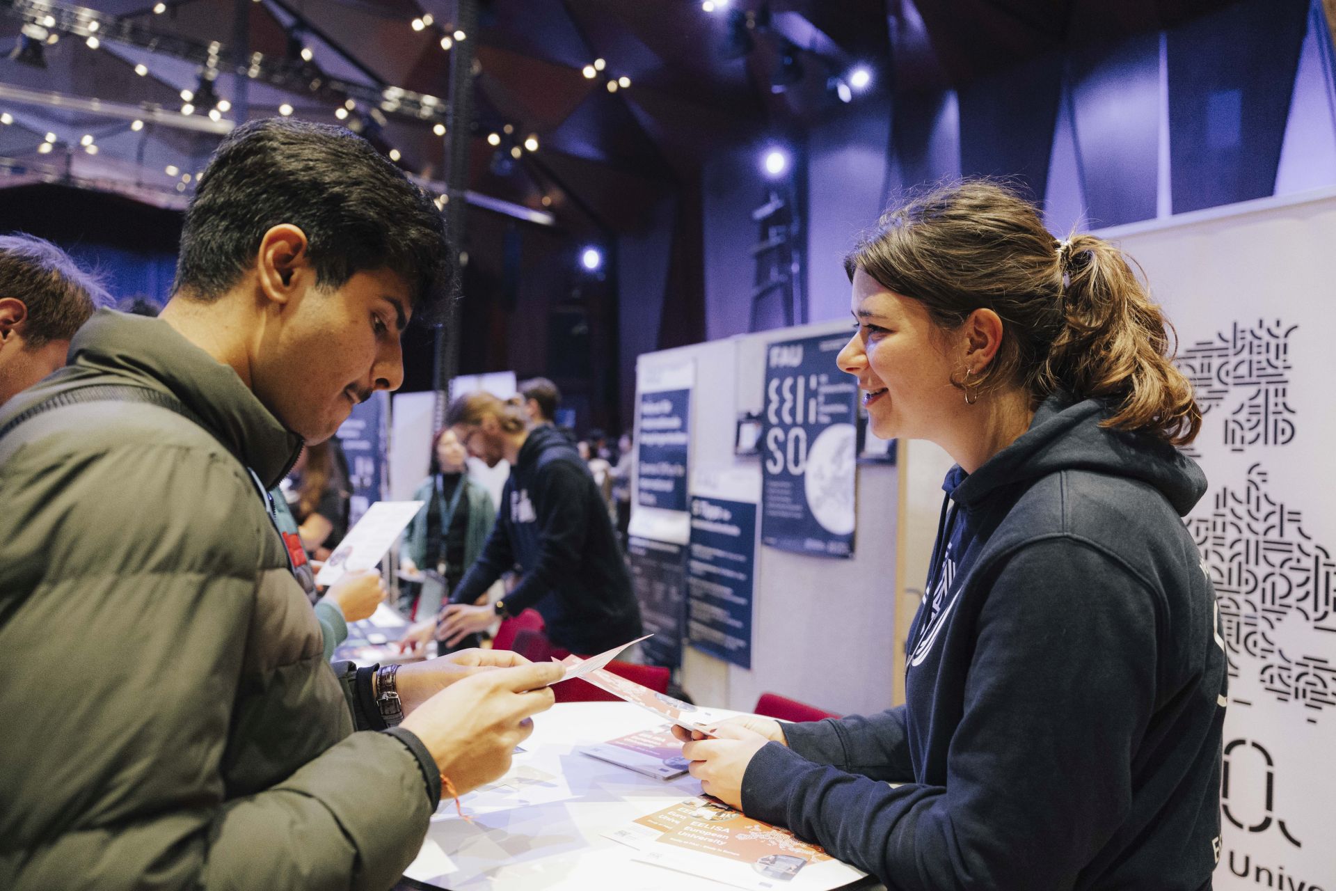 Ein Student im Gespräch mit einer FAU-Beschäftigten am Stand von EELISA.