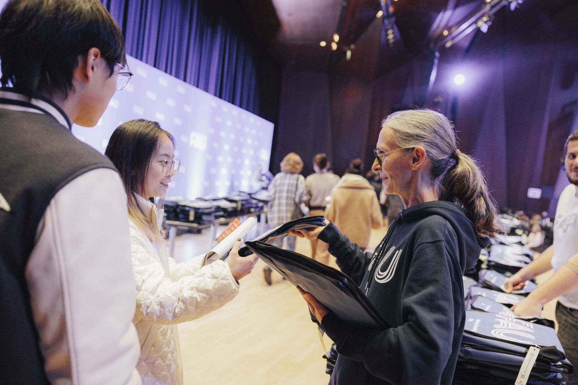 FAU-Vizepräsidentin Andrea Breard überreicht eine FAU-Tasche an eine Studentin.