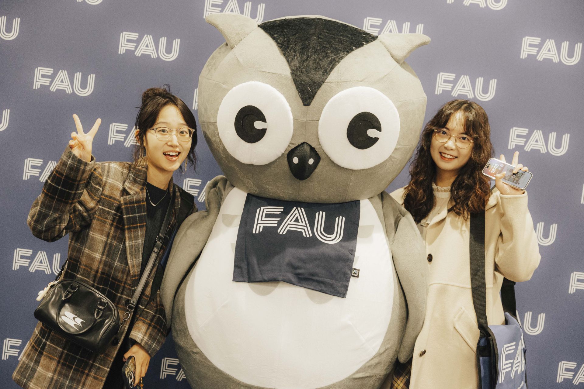 Zwei Studentinnen mit der FAU-Eule.