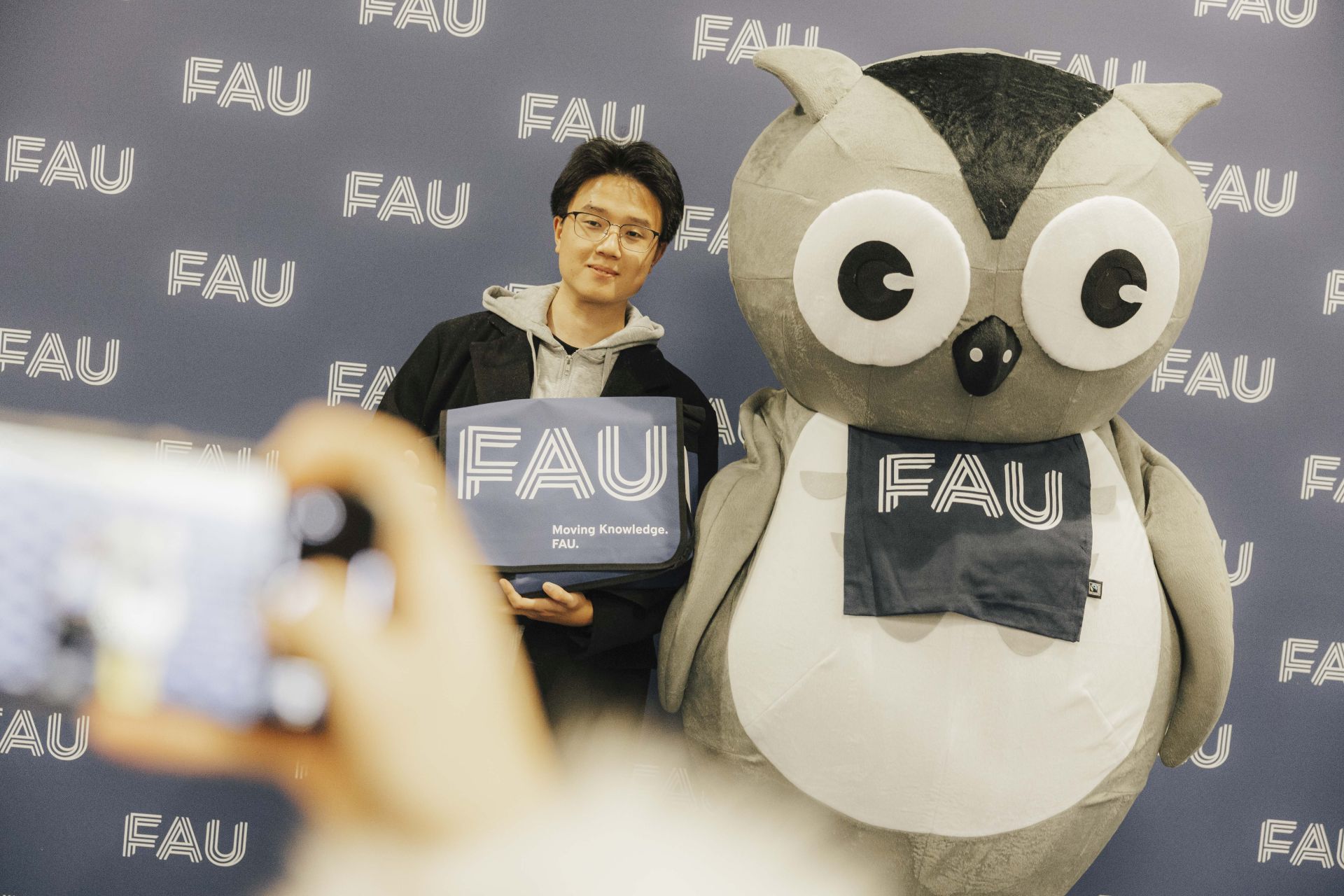 Ein Student mit der FAU Eule.