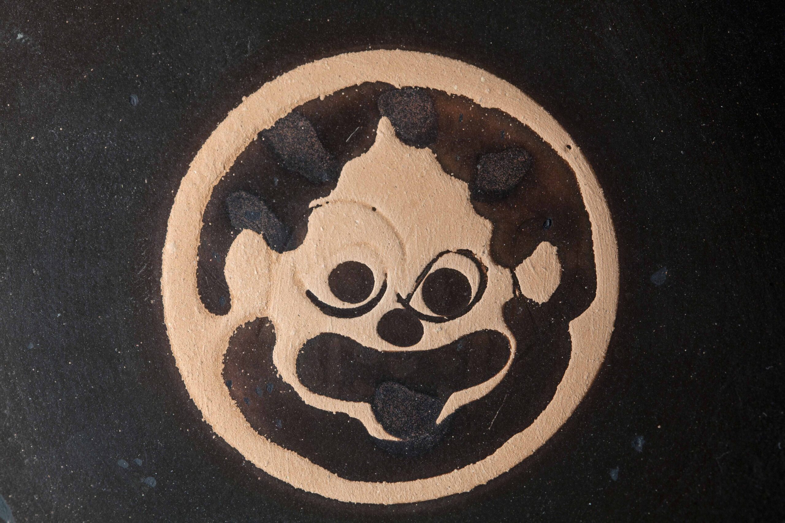 Verlaufenes Haupt einer zungenbleckenden Medusa.