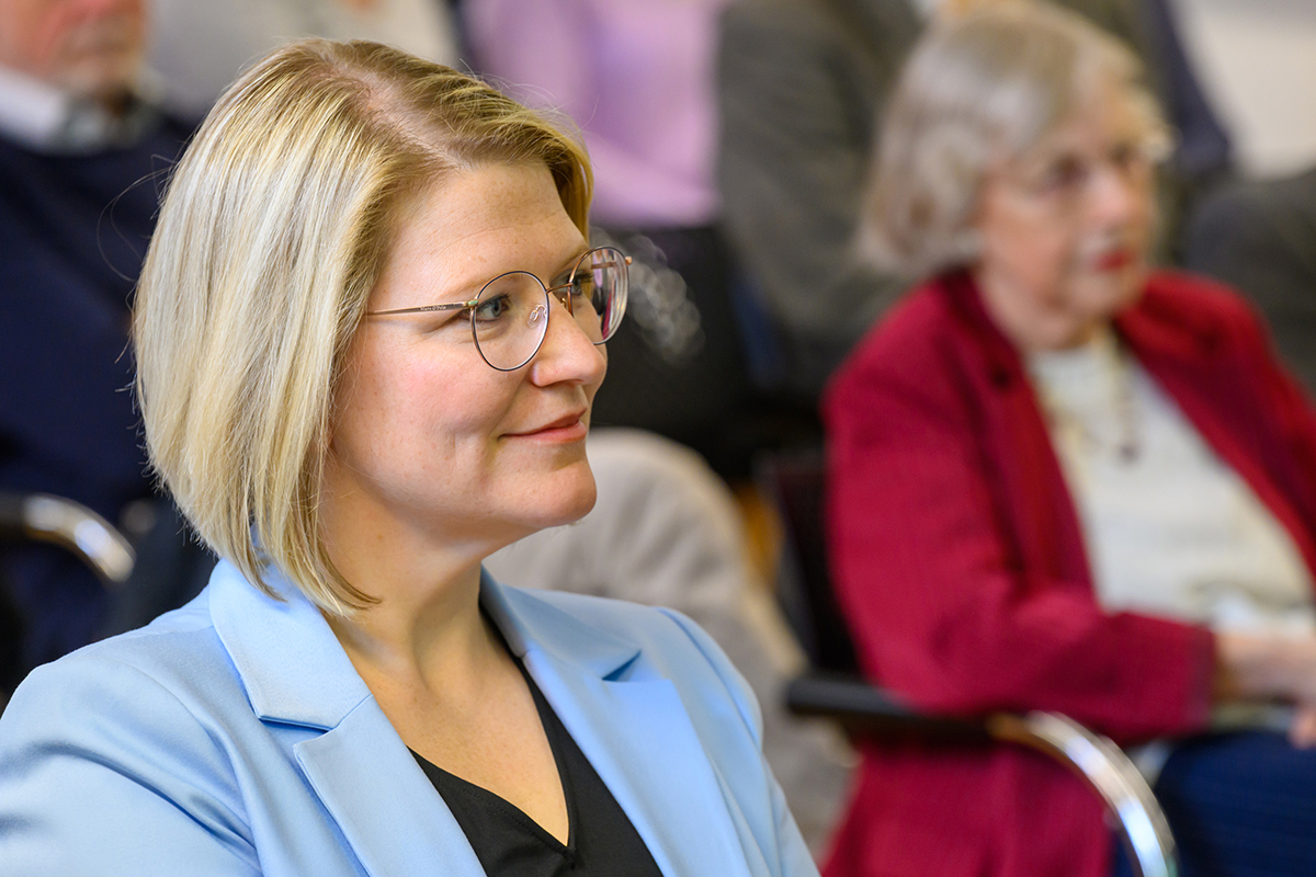 Porträt von Gensberger, eine blonde frau im mittleren Alter mit Brille und Pagenschnitt.
