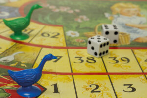 Brettspiel mit Gänsefigur und Würfel
