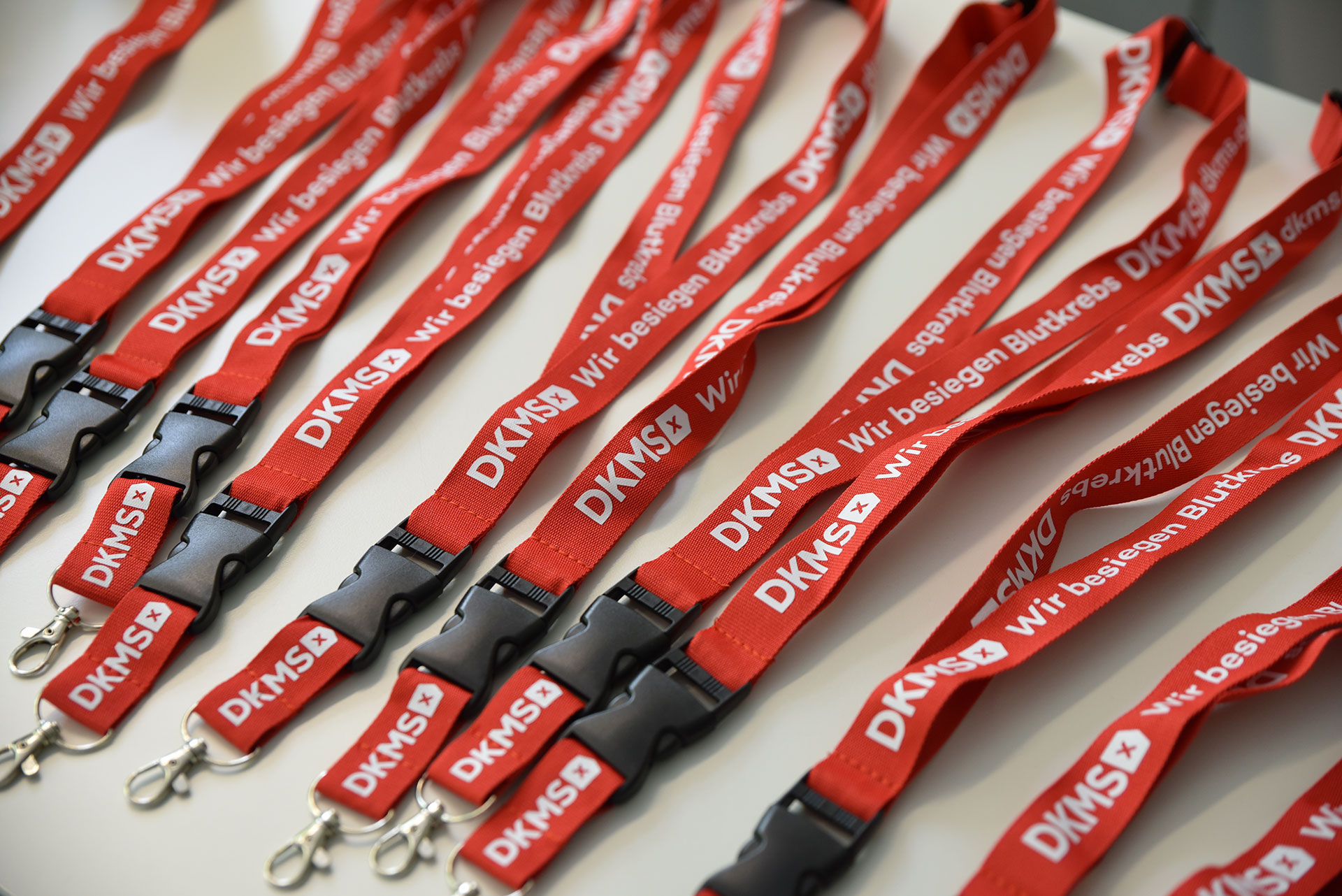 Auf einem Tisch liegen mehrere Schlüsselanhänger der DKMS.
