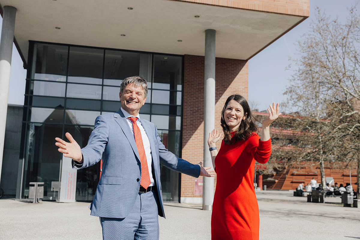 Horneger und Lisa Handke mit erhobenen armen vor dem Gebäude der Wiso.