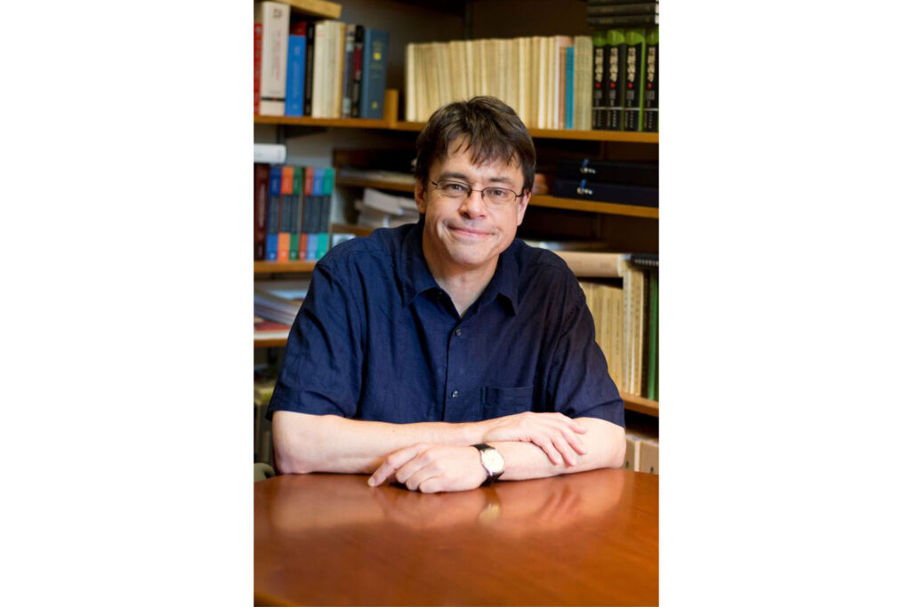 Michael J. Puett sitzt an einem Tisch.