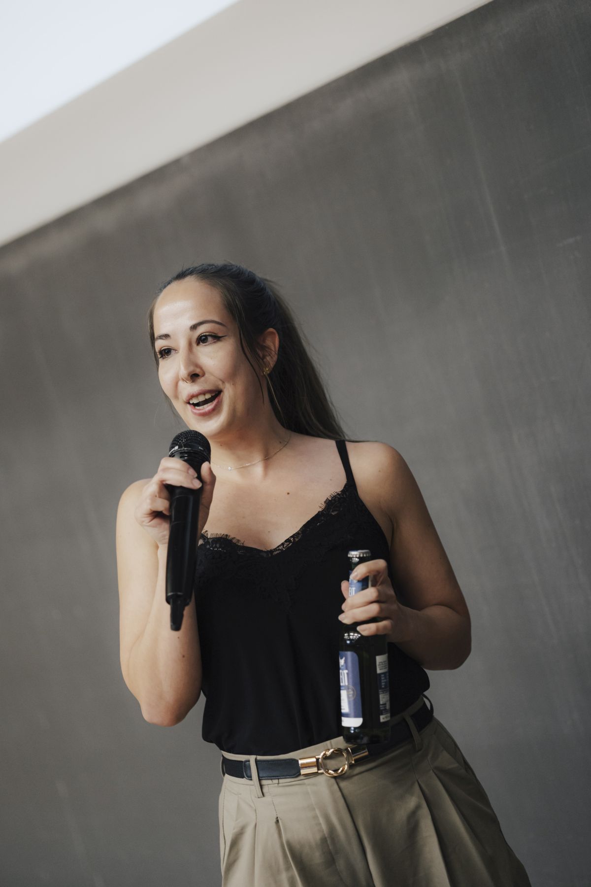 Slammerin mit Getränk und Mikrofon in der Hand