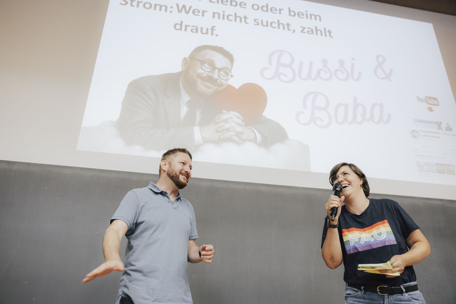 FAU-Wissenschaftskommunikatorin Laura Kneppe am Mikrofon begrüßt den Slammer vor Publikum