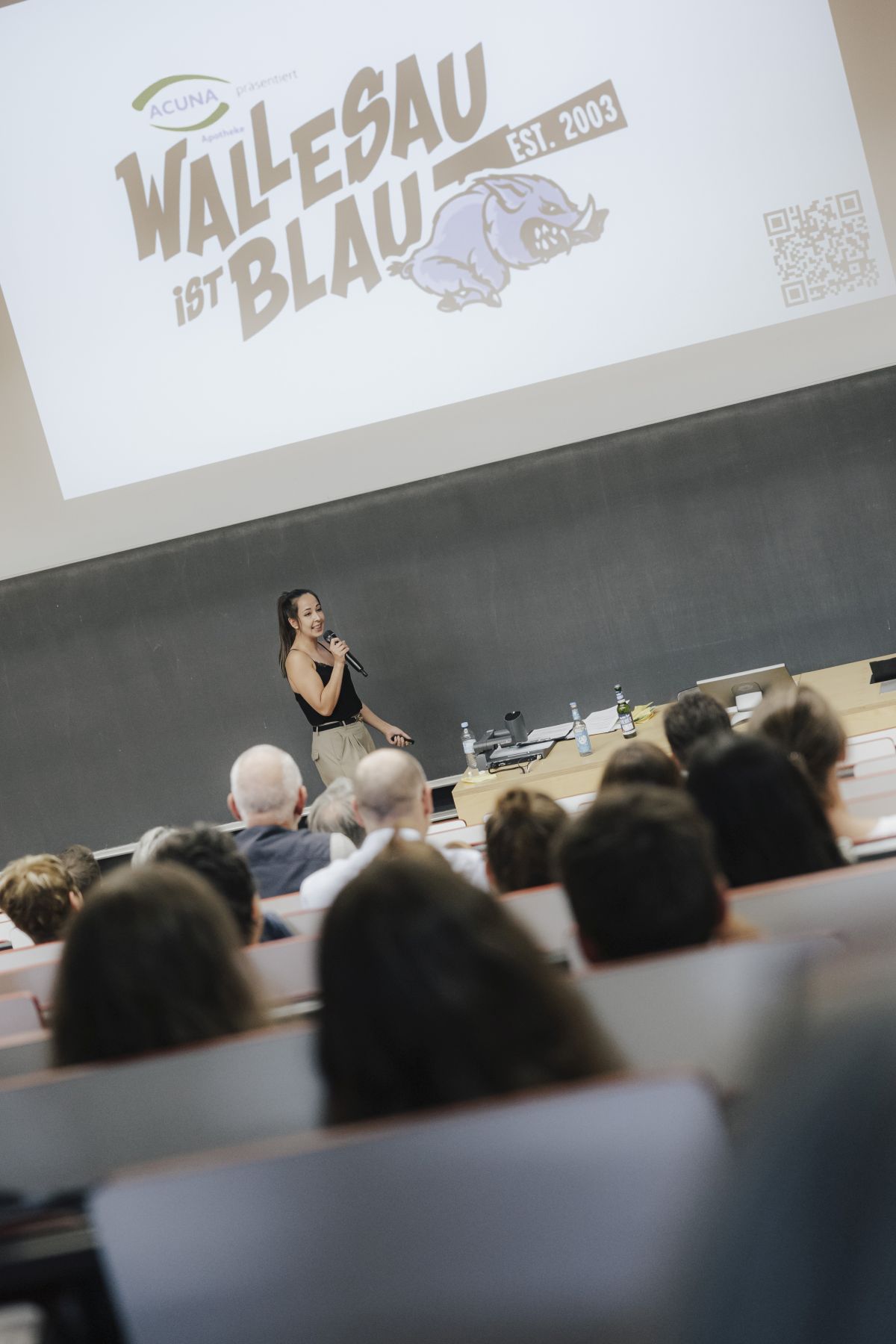 Slammerin in Hörsaal mit Menschen vor ihrer Präsentation 