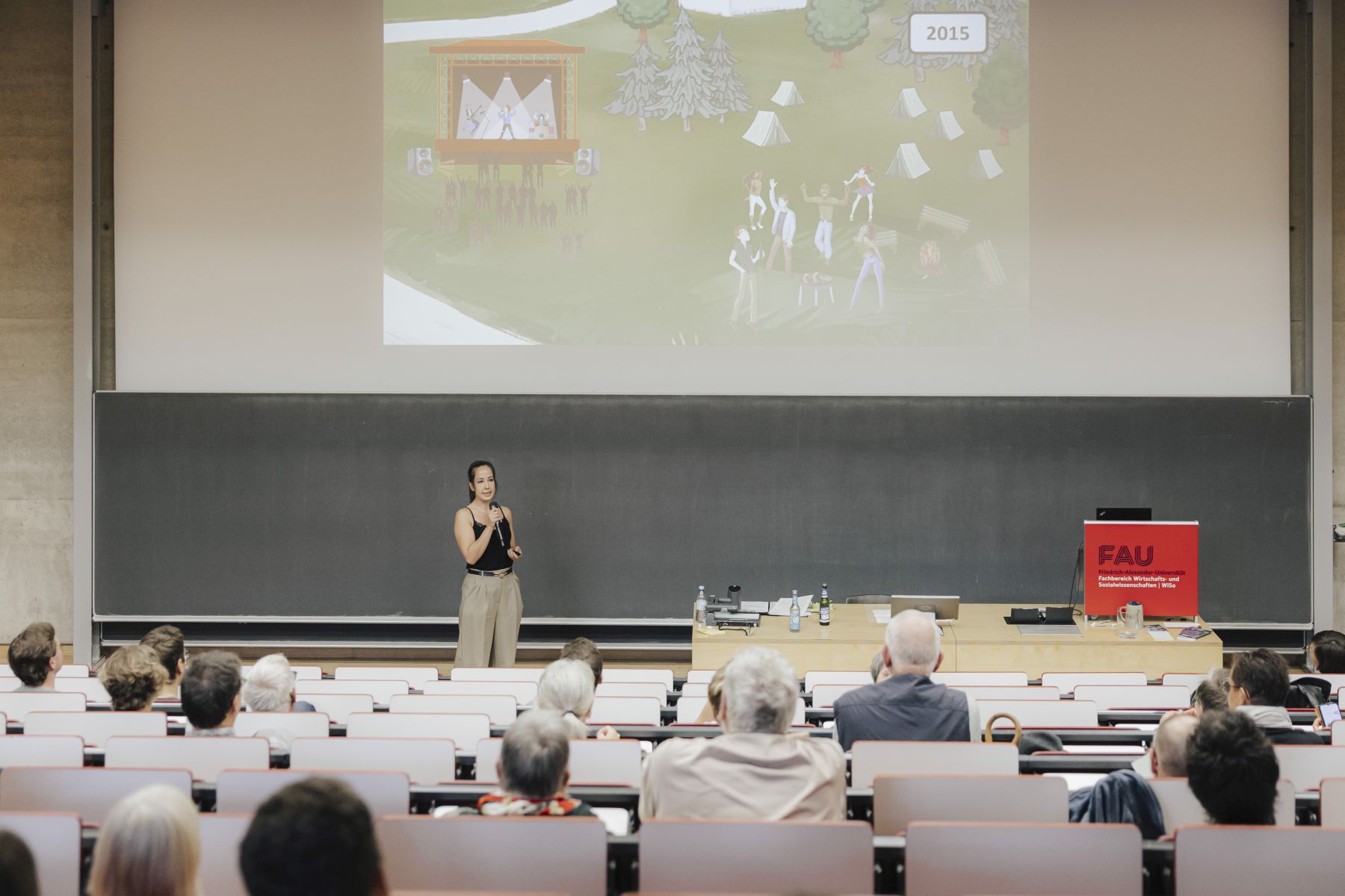Slammerin in Hörsaal mit Menschen vor ihrer Präsentation