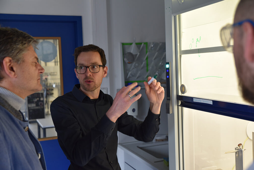 Prof. Vogel erklärt Hornegger etwas im Labor