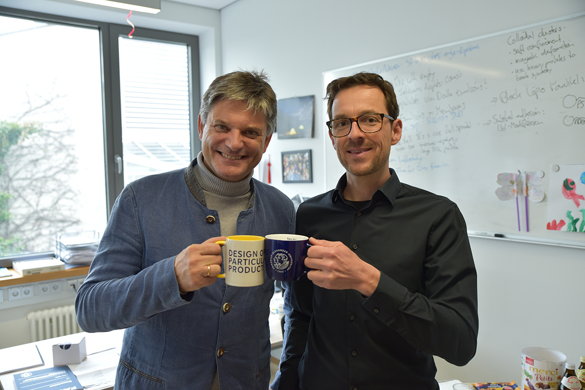 Prof. Vogel und Präsident Hornegger stoßen mit zwei Tassen an. 