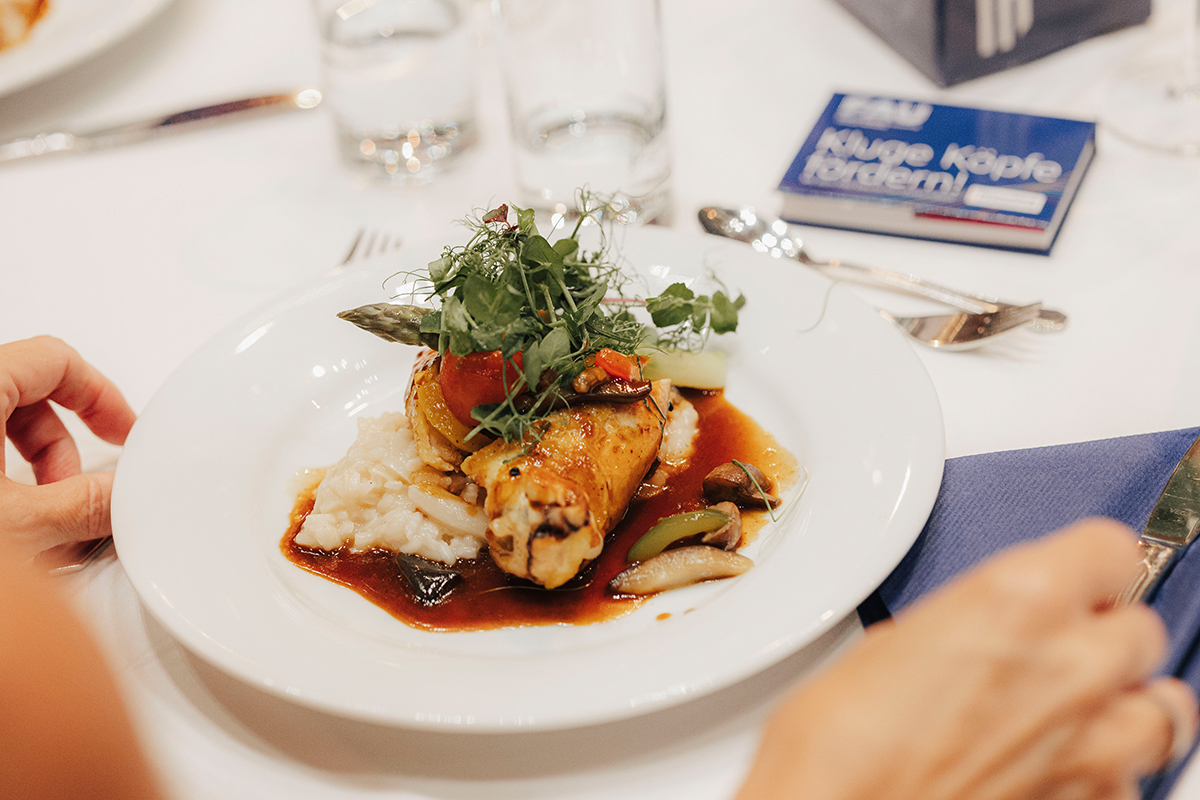 Ein weißer Teller auf dem Tisch mit einem Hauptgericht.