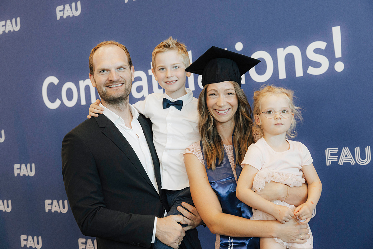Eine Jubilarin mit Partner und zwei Kindern vor der Fotowand.