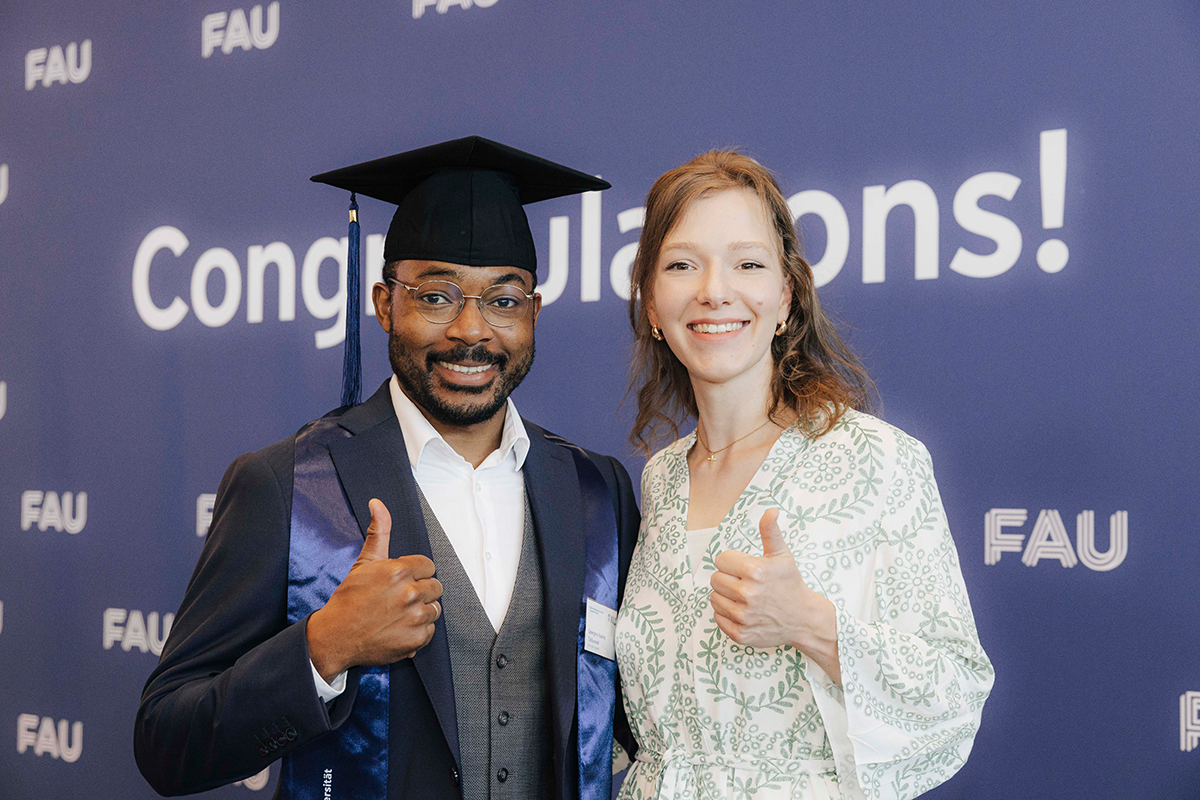 Ein Jubilar in feierlicher Kleidung neben seiner Begleitung, beide geben einen "Daumen hoch".