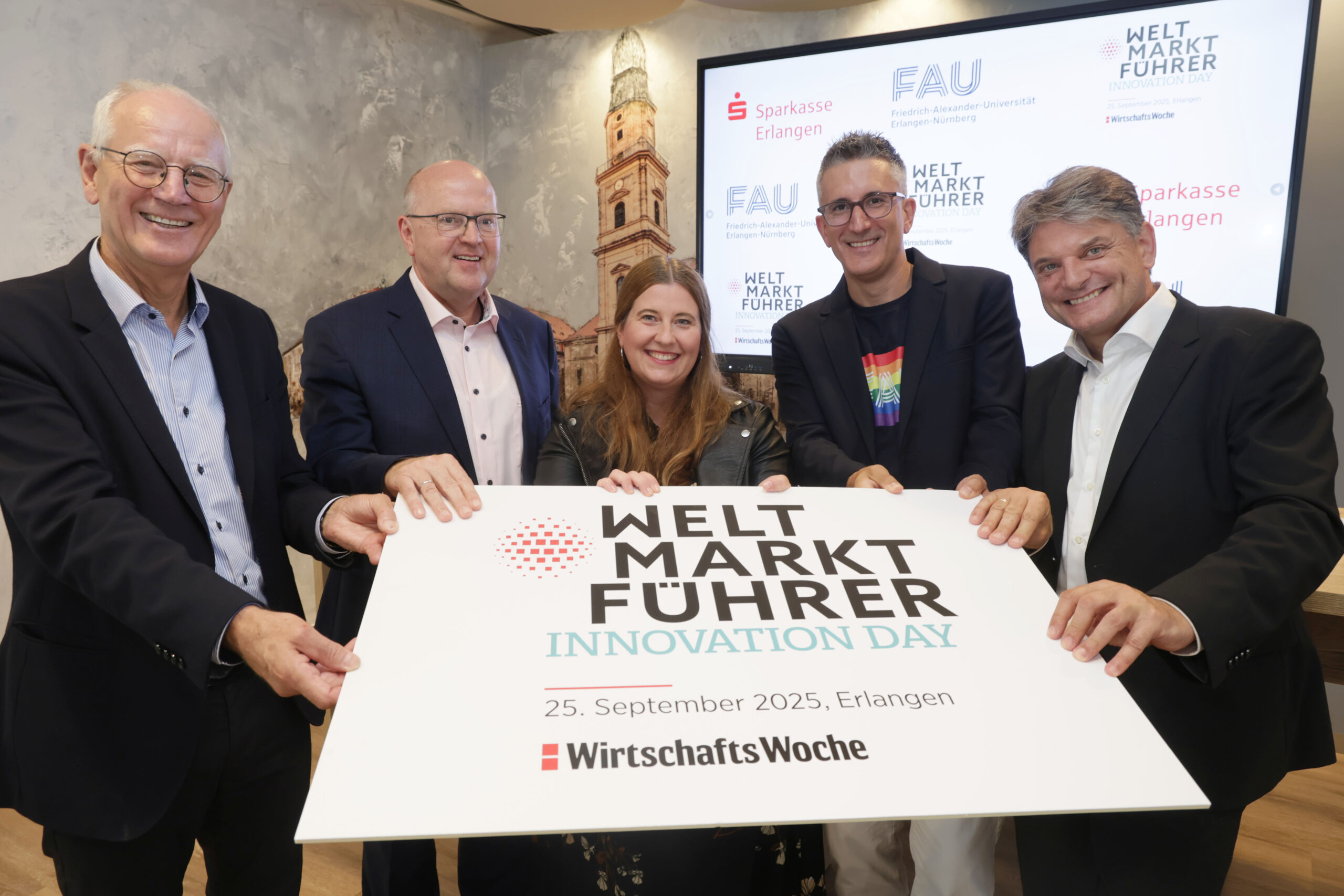 Die Personen halten gemeinsam ein schild in die Höhe mit dem Logo Weltmarktführer Innovation Days