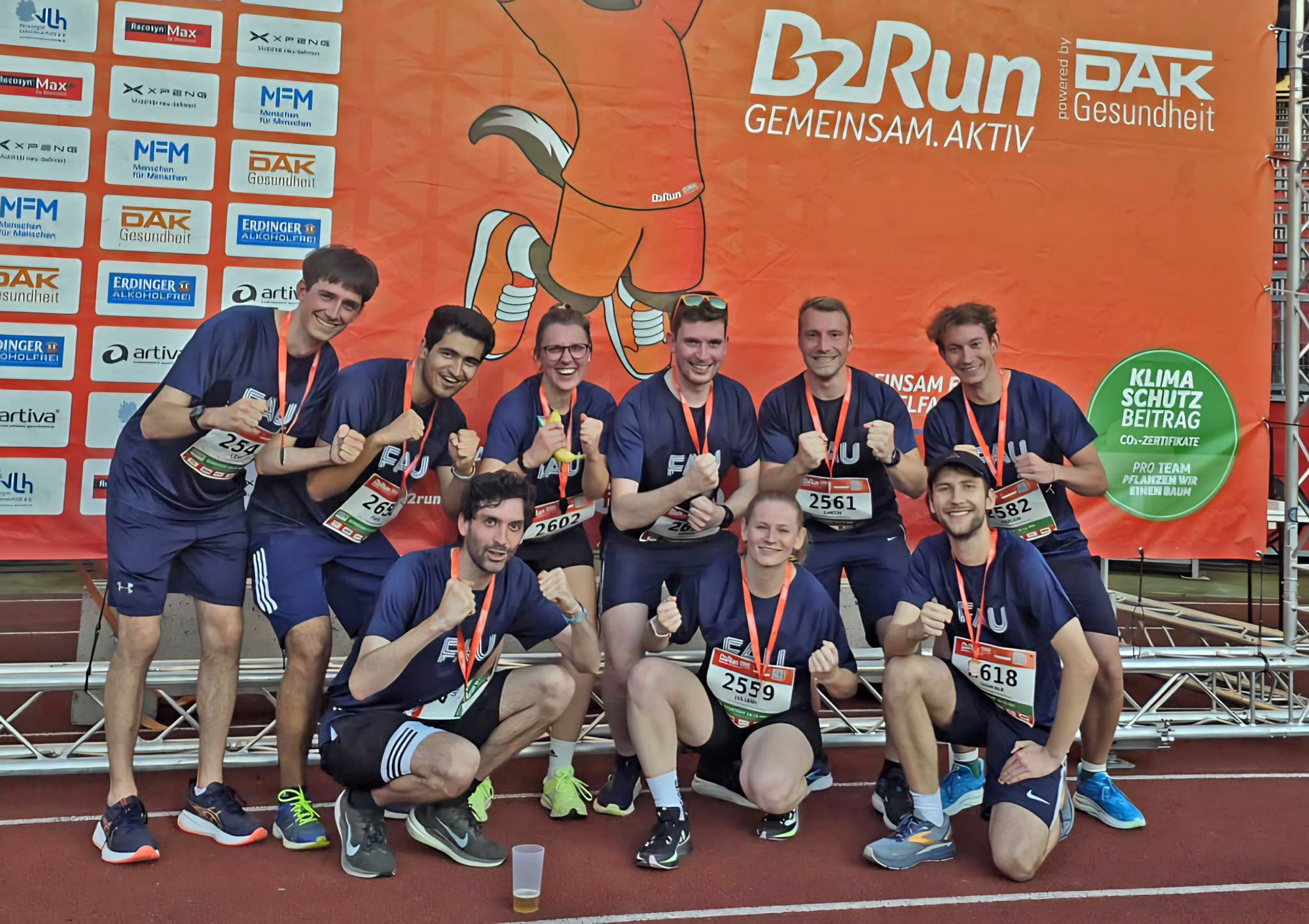 Gruppenfoto mit Personen, die im FAU-Team beim B2run Firmenlauf in Nürnberg mitgemahct haben in Sportkleidung mit Medaillen