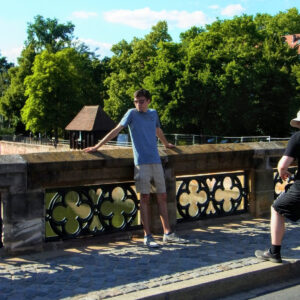 Ein junger Mann mit Sonnenbrille lehnt an einer Mauer