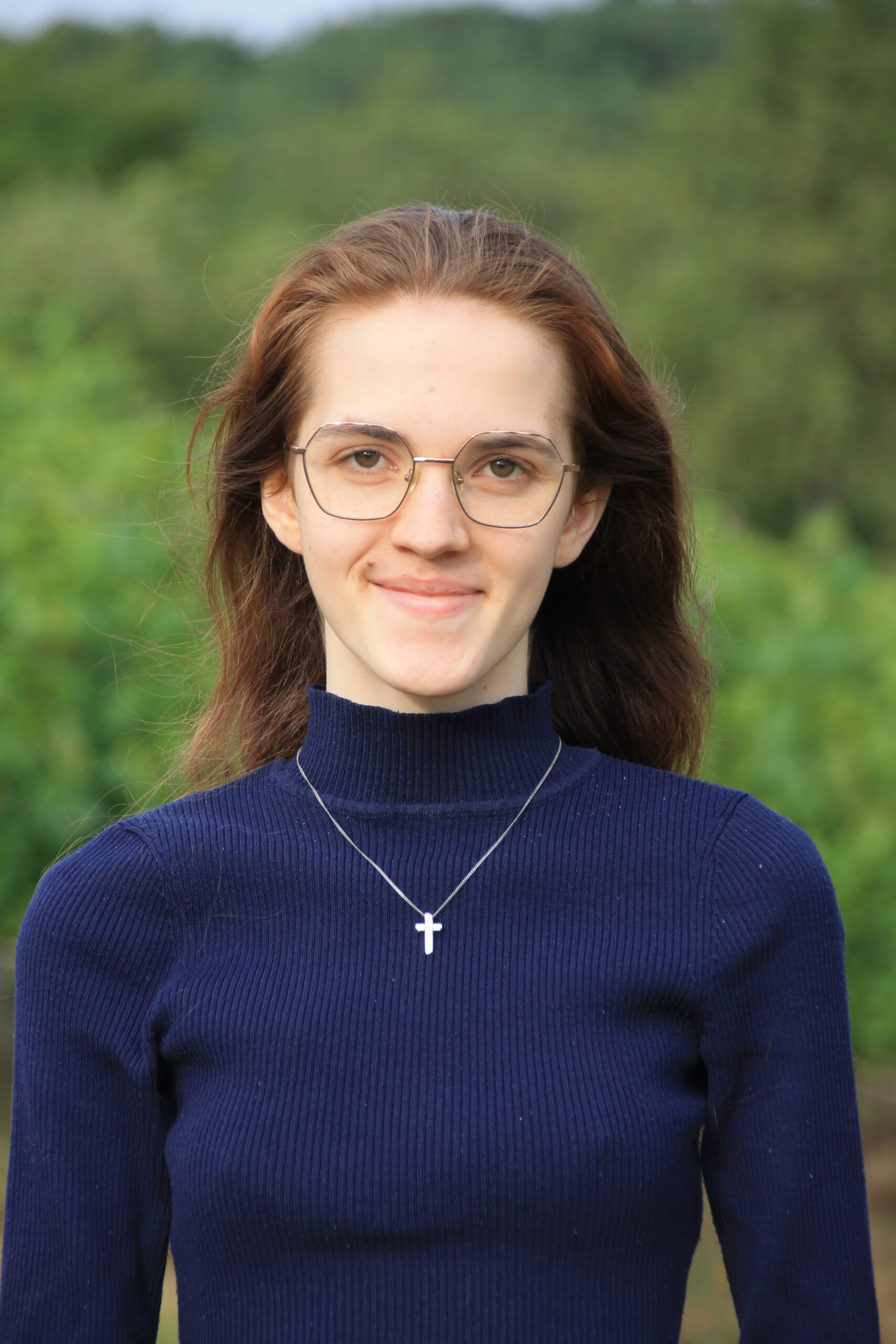 Ein Porträt von Rebekka Kampe vor einem Waldhintergrund