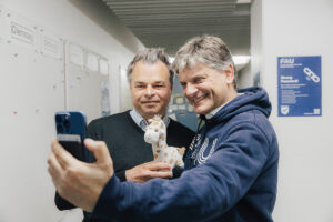 Der Unipräsident Hornegger und Prof. Dr. Kai Phillip Schmidt machen zusammen ein Selfie.