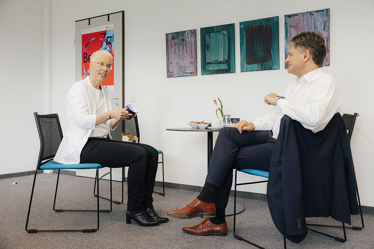 Prof. Weise und Präsident Hornegger sitzen gemeinsam an einem Tisch und reden miteinander.