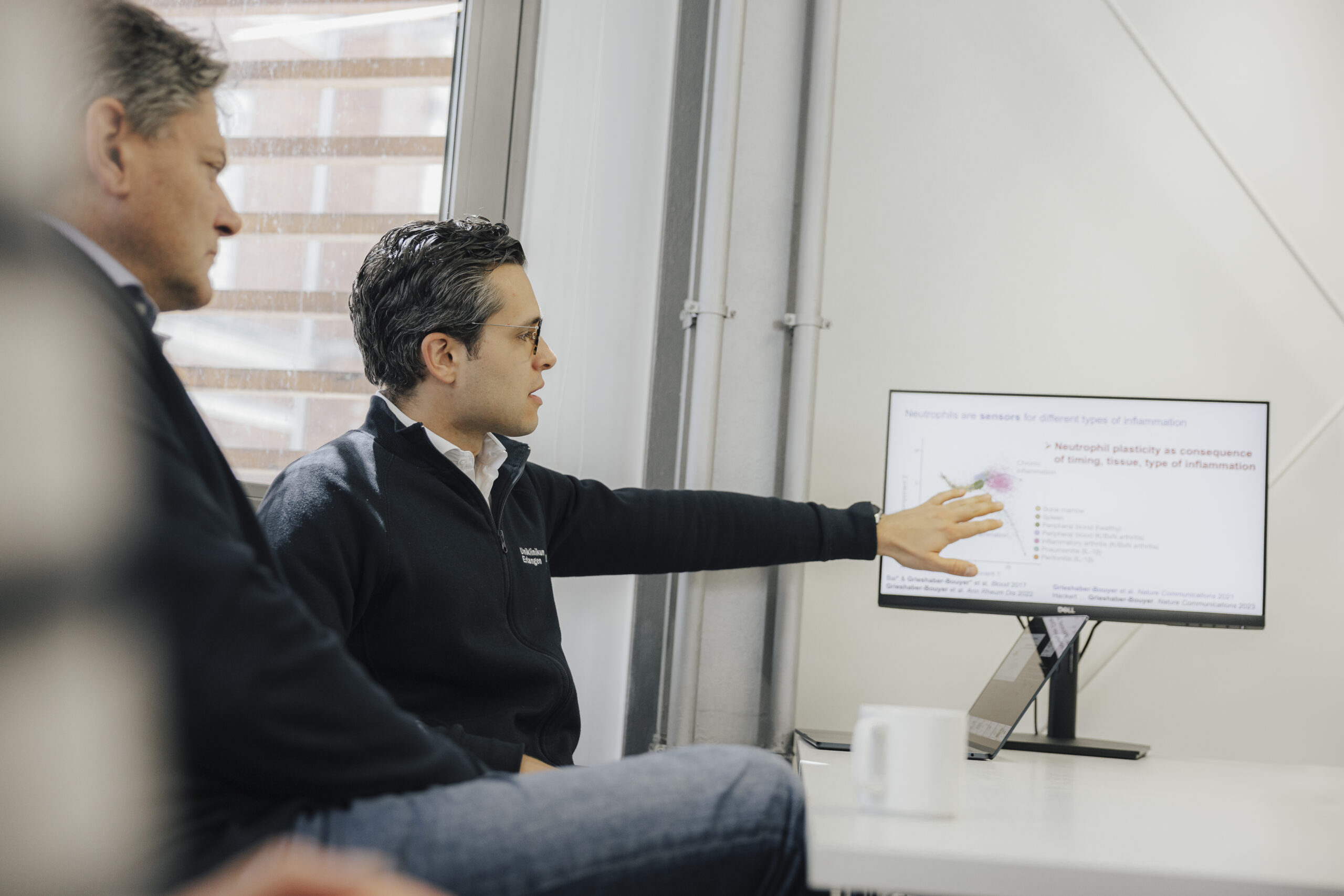 Prof. Grieshaber-Bouyer erklärt Präsident Hornegger etwas an einem Bildschirm.