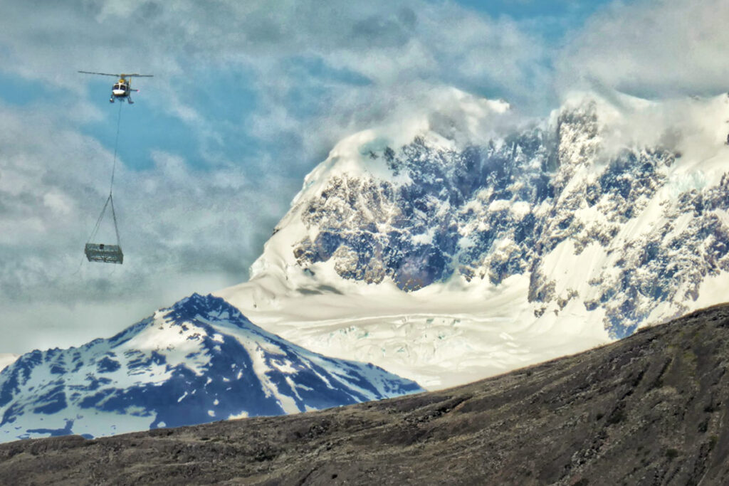 Helikopter der mit großer antenen über berge fliegt. 