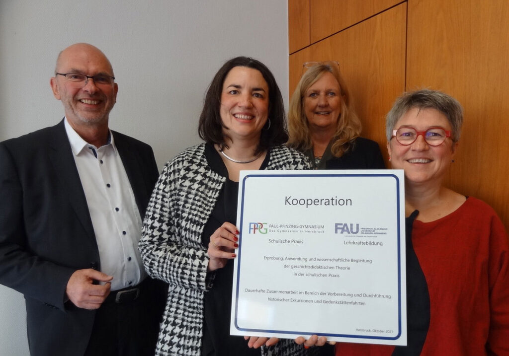 Personen halten den Kooperationsvertrag in die Kamera