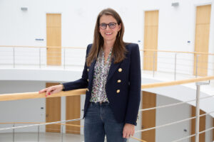 Prof. Dr. Stefanie Corradini steht im Treppenhaus des FAU-Hauptgebäudes