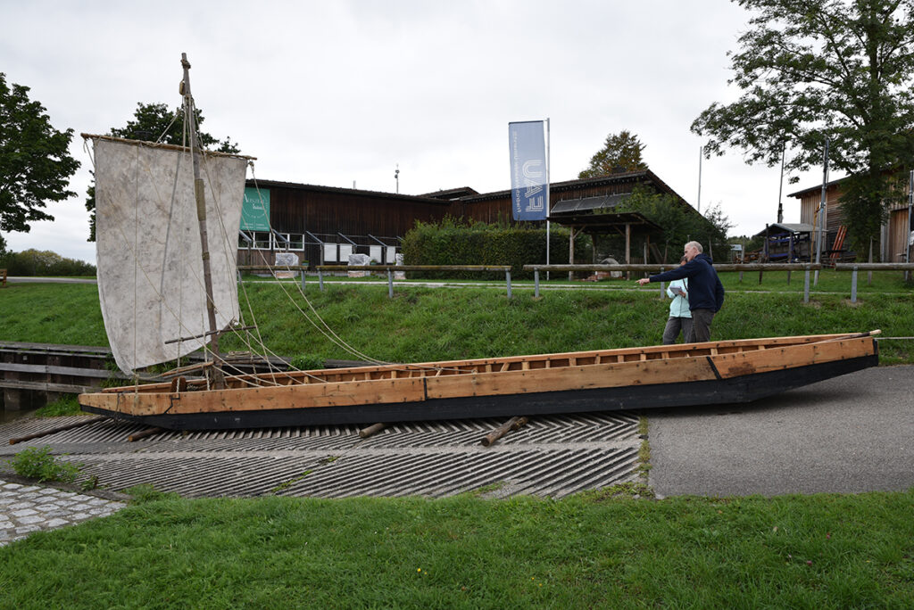 Das neue FAU-Römerboot: Die Alchmona rediviva. Ein kantiges Boot mit einem Mast und flachem Boden ohne Kiel. 