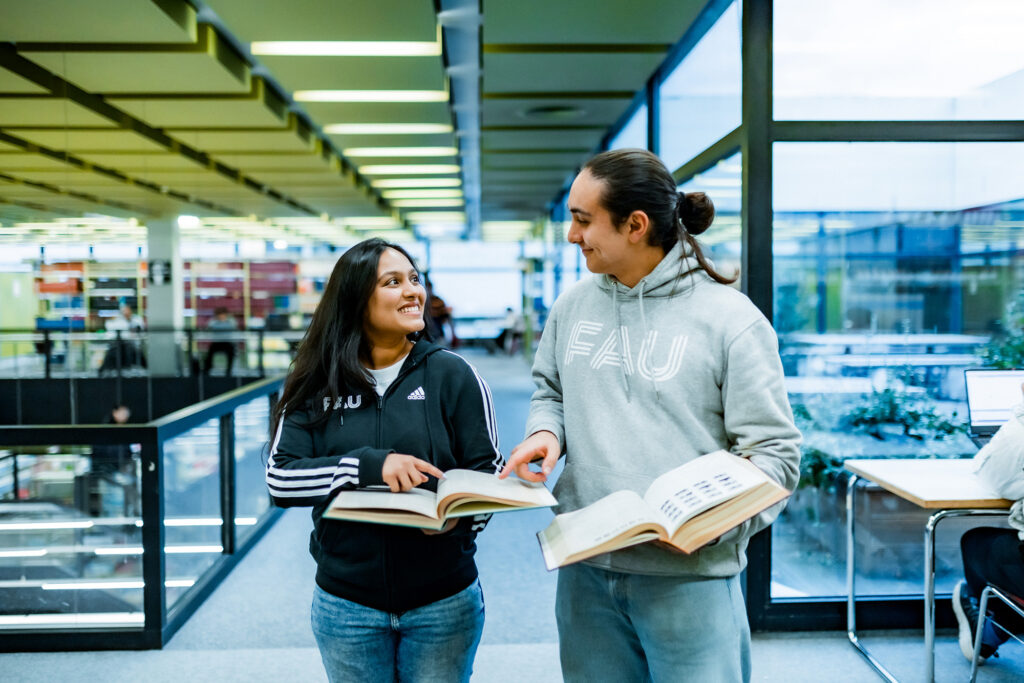 Zwei Studierende laufen einen Gang entlang