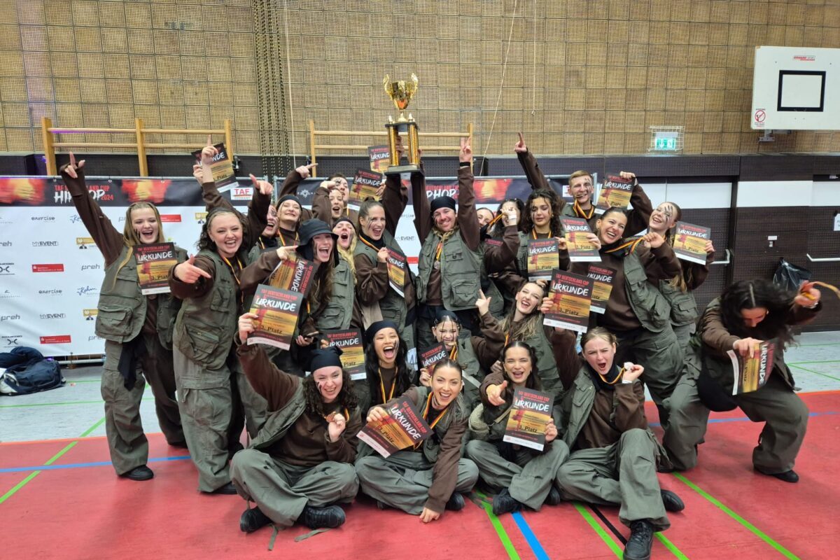 Gruppenfoto von über 10 Menschen alle in grünen Hosen und Westen.